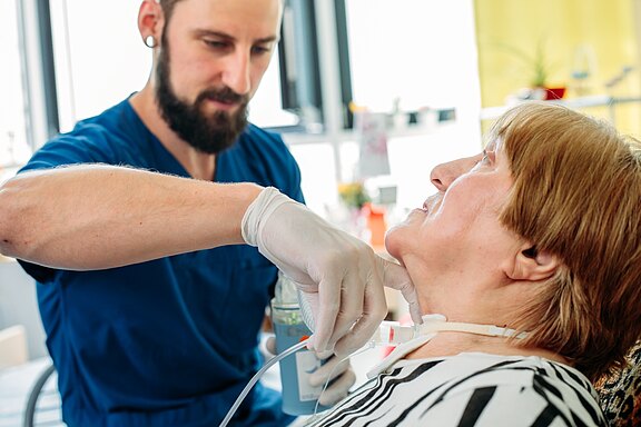 Ein Pfleger betreut eine Intensivpflege-Patientin. Ein Pfleger betreut eine Intensivpflege-Patientin